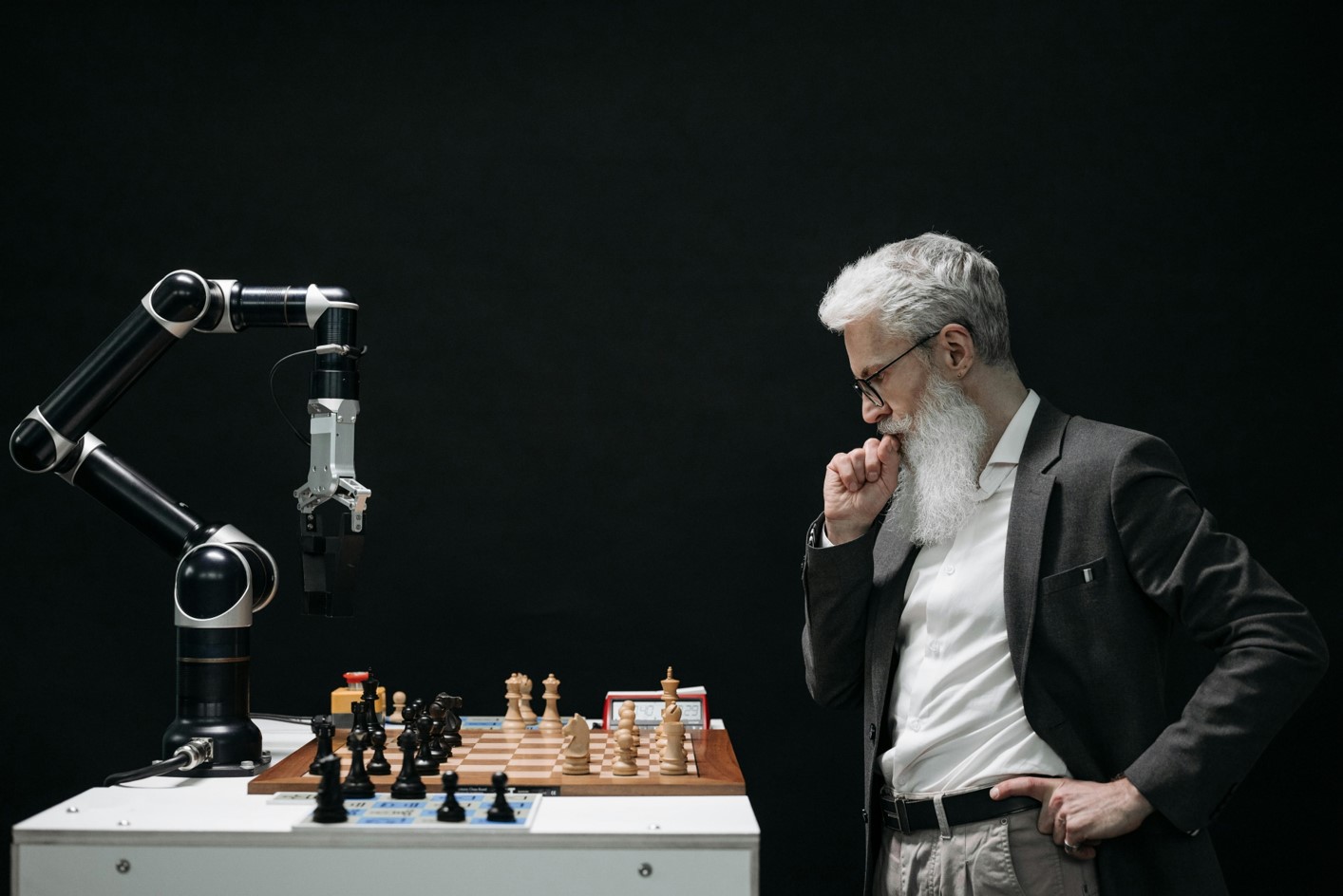 The planner - Man and robot arm looking at a chessboard